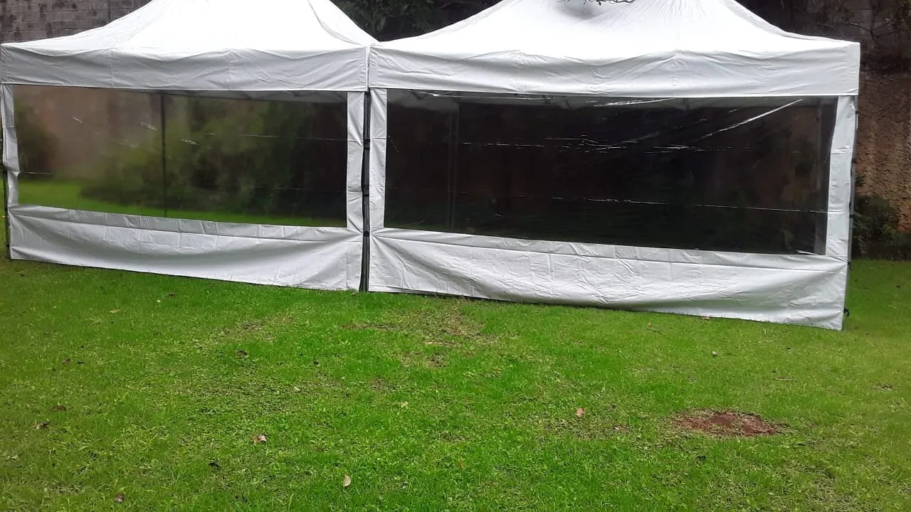 Tenda com fechamento lateral transparente montada em jardim