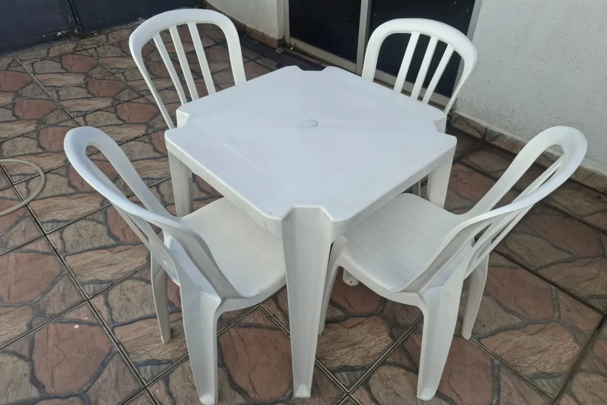 Mesa quadrada branca com 4 cadeiras plásticas
